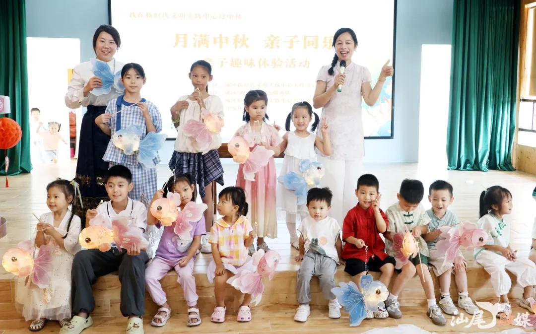 中秋亲子趣味体验活动中，孩子们展示自己制作的灯笼。